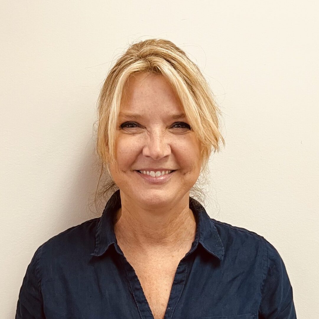 A woman with blonde hair wearing a blue shirt.